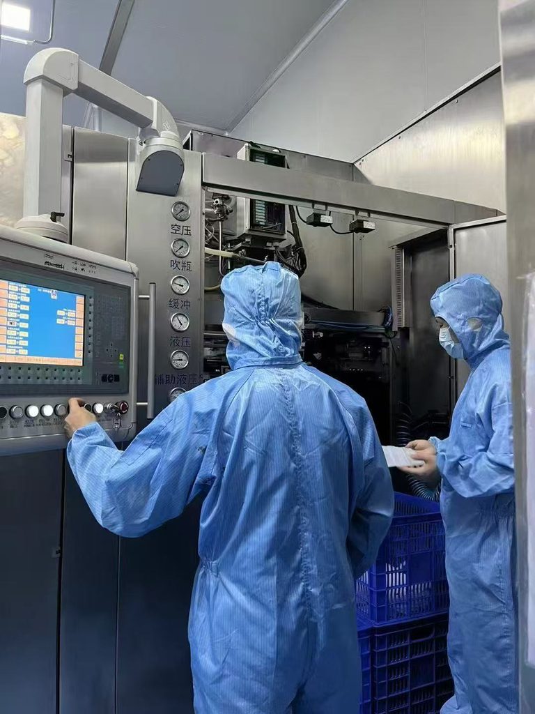 Sunone production staff operating manufacturing equipment in a controlled cleanroom environment